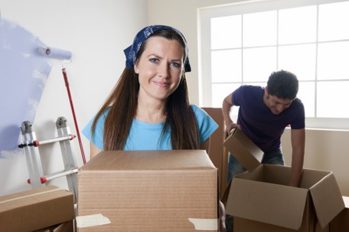 Professional movers carrying wrapped furniture down stairs in Marylebone
